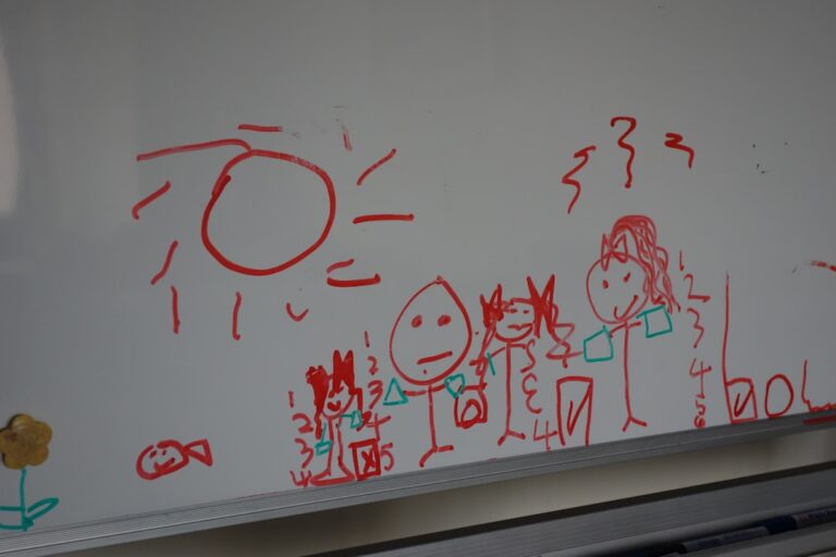 Children's drawing of sun, people, and fish