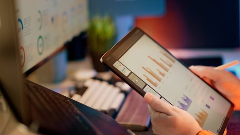 Someone analyzes financial data on a tablet — illustrating How to Increase AI Visibility: A 30-Day Practical Plan
